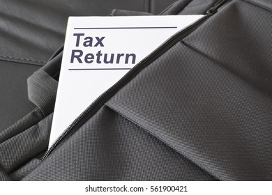 Open briefcase with some documents in it. A paper with the title TAX RETURN written on it. Empty copy space for Editor's text.