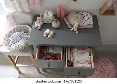 Open Cabinet Drawers With Baby Shoes And Clothes In Child Room