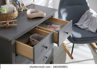 Open Cabinet Drawers With Clothes And Different Items In Child Room