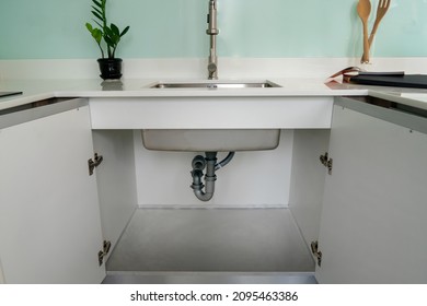 Open cabinet under sink 1 bowls with installed water pipe, water filter , Accessories aluminum under cabinet sink protection .White kitchen cabinet.
