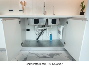 Open cabinet under sink 2 bowls with installed water pipe, water filter , Accessories aluminium under cabinet sink protection .White kitchen cabinet. - Powered by Shutterstock