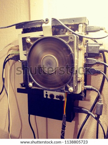 Open Cage Computer Tower hanging on white wall with spinning blades.