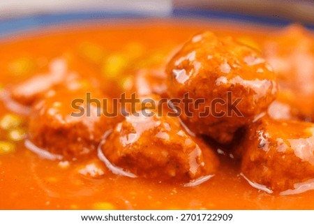 Open can of meatballs and peas, rustic background with wooden board, ready meal scene.