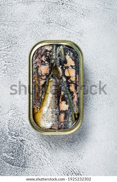 Open can with sardine in olive oil. White\
background. Top view