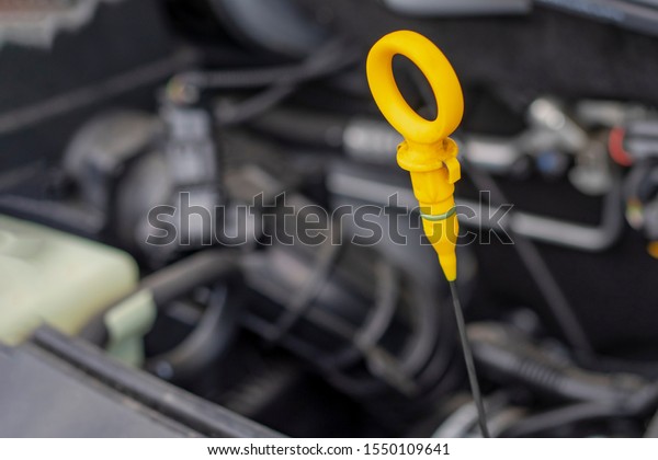 open car hood. get the probe. it is yellow.\
checking the oil level.