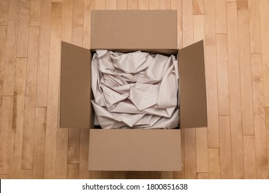 Open Cardboard Box Filled with Paper Packaging. Online Order and Unboxing a New Delivery from the Mail. Transportation and Consumer E-Commerce Concept