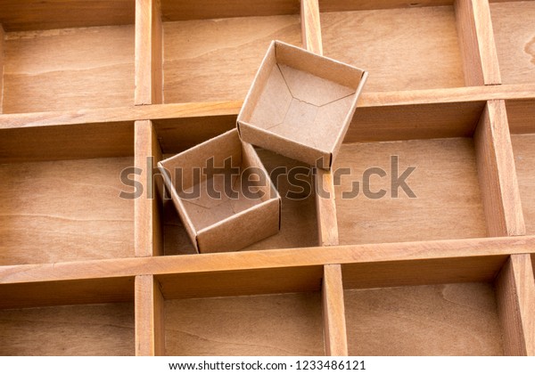 Open\
cardboard box inside a wooden box with\
compartments