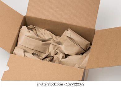 Open cardboard box with paper filling cushioning, safe transport