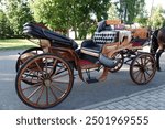 An open carriage for the transportation of passengers. A breech with a place for the coachman and passengers. A medieval cab. A wooden carriage with huge wheels and leather seats. 