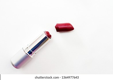 Open Case With Broken Burgundy Lipstick On White Background