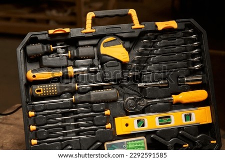 open case with locksmith tools. inside open-end wrenches, a set of screwdrivers, a liquid level, a ratchet