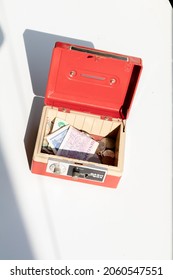 An Open Cash Box Filled With Banknotes And Coins