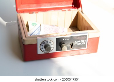 An Open Cash Box Filled With Banknotes And Coins