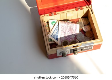 An Open Cash Box Filled With Banknotes And Coins