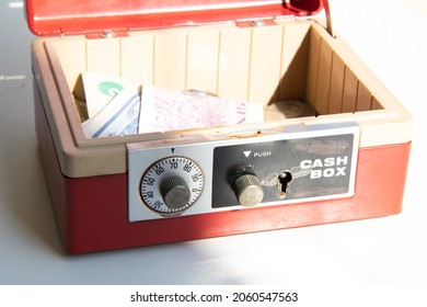 An Open Cash Box Filled With Banknotes And Coins