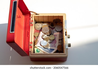 An Open Cash Box Filled With Banknotes And Coins