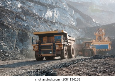 open cast mine dump trucks drive alone industrial area of iron ore quarry - Shutterstock ID 2084134138