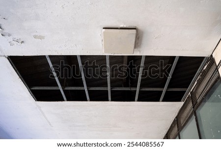Open ceiling panel of a school building damaged from heavy rain and storm. Disaster and construction work concept. 