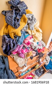 Open Chest Drawers With Drop-down Clothes And Piles Of Clothes Around In A Mess.View From Above