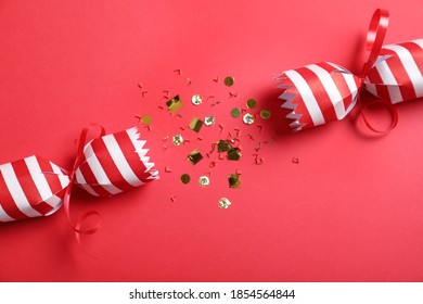 Open Christmas Cracker With Shiny Confetti On Red Background, Top View