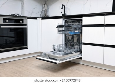 Open clean empty dishwasher in kitchen. Home appliance