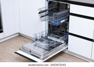 Open clean empty dishwasher in kitchen. Home appliance