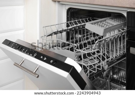 Open clean empty dishwasher in kitchen. Home appliance