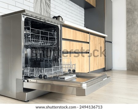 Open clean empty dishwasher in kitchen. Home appliance