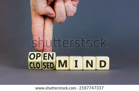 Open or closed mind symbol. Businessman turns cubes and changes concept words closrd mind to open mind. Beautiful grey table, grey background, copy space. Business open or closed mind concept.