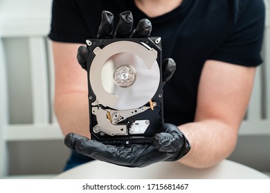 open Computer Hard Drive in Hands in black gloves. master of repair.