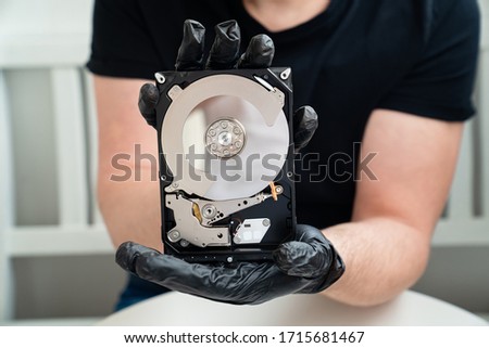 open Computer Hard Drive in Hands in black gloves. master of repair.