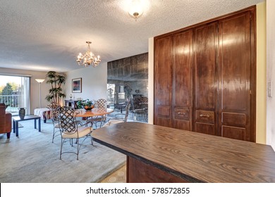 Open Concept Living And Dining Area In Apartment Accented With Glossy Tile Wall And Wood Top Table With Wrought Iron Chairs. Northwest, USA