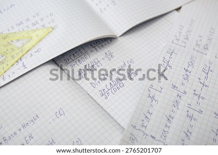 Open copybooks with math formulas as background, closeup