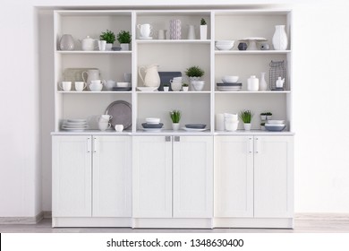 Open Cupboard With Clean Dishes In Kitchen