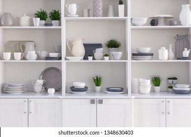 Open cupboard with clean dishes in kitchen
