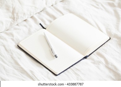 Open diary in bed, mock up. Selective focus