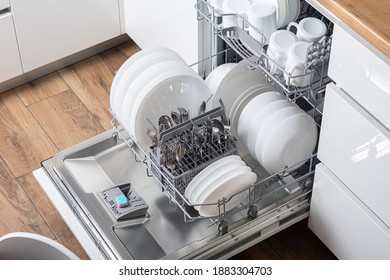 Offener Geschirrspüler mit sauberem Geschirr in der weißen Küche