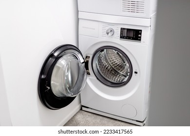 Open door of front load washing machine in laundry room. Clean empty drum of washing machine.  - Powered by Shutterstock