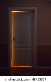 Open Door To Illuminated Room From Dark Hall