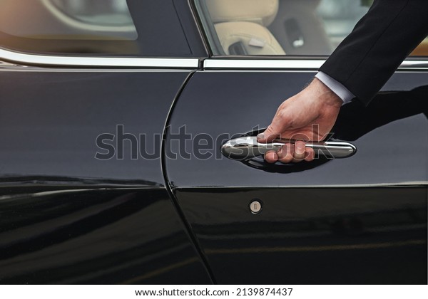 Open the door to a life of luxury.\
Cropped shot of a well dressed man opening a car\
door.