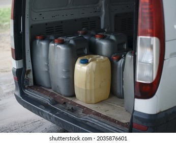 Open Door Of A Minivan Full Of Plastic Oil Or Fuel Canisters, Outdoor Shot