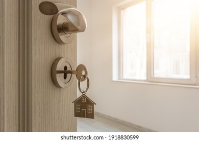 Open door to a new home with key and home shaped keychain. Mortgage, investment, real estate, property and new home concept - Shutterstock ID 1918830599
