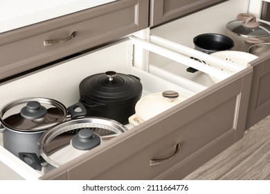 Open drawer with clean kitchenware, closeup