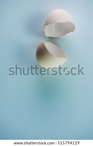 Open egg shells on blue background with soft shadows. Extremely shallow depth of field.  
