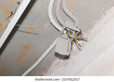 open electrical junction box and wires on the ceiling - Shutterstock ID 2157612517