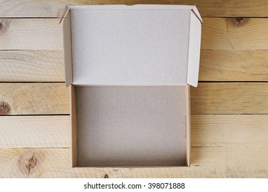 Open, Empty Box, Front View,  On Natural Wooden Table. Place For Text.