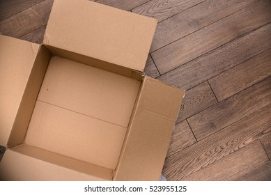 A Open Empty Carton Box On Wood Floor