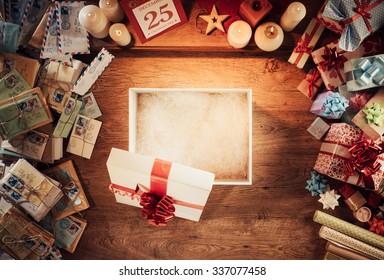 Open Empty Christmas Gift Box On A Wooden Desktop Surrounded By Letters And Presents, Top View