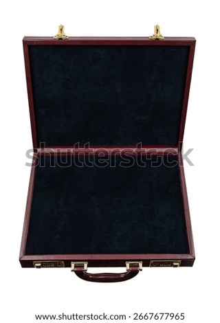 An open, empty, dark red briefcase with a black velvet interior.