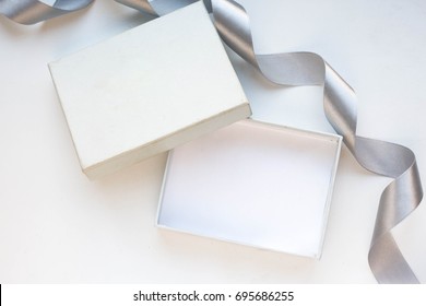 Open Empty Gift Box On White Table. Colorful Gift Box With Ribbon Bow Present On Holiday
